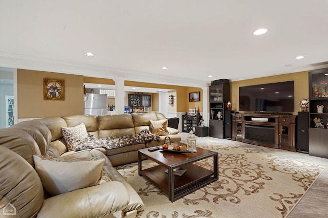 living room featuring recessed lighting, a fireplace, and ornamental molding