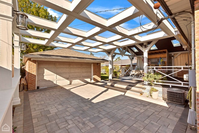 view of patio / terrace featuring a detached garage, central AC unit, and a pergola