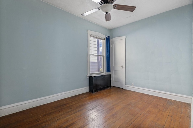 unfurnished room featuring baseboards, radiator, ceiling fan, and hardwood / wood-style flooring