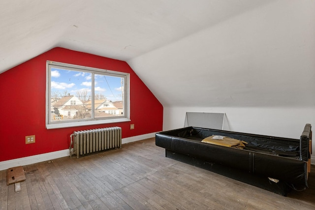 bonus room with baseboards, radiator heating unit, lofted ceiling, and hardwood / wood-style floors