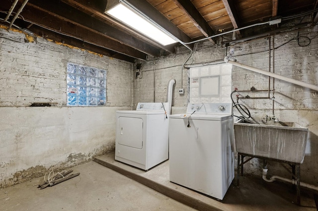 clothes washing area featuring washing machine and clothes dryer, laundry area, and a sink