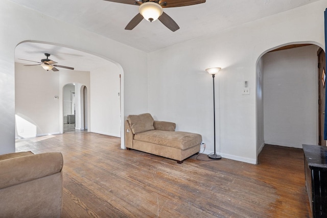 sitting room with arched walkways, baseboards, a ceiling fan, and hardwood / wood-style floors