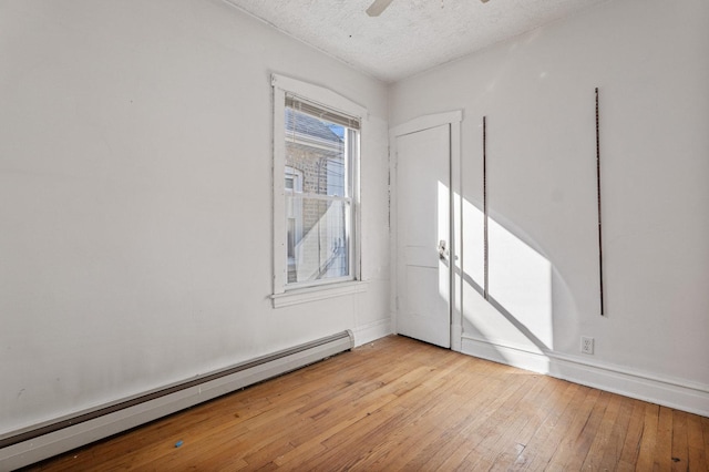 unfurnished bedroom with light wood finished floors, a textured ceiling, a ceiling fan, and a baseboard radiator