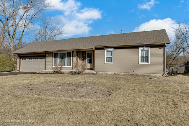 ranch-style house featuring a front lawn, an attached garage, and roof with shingles