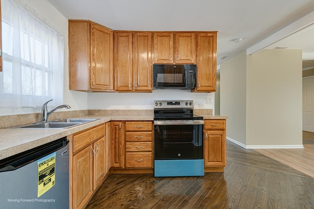 kitchen featuring dark wood-style floors, stainless steel appliances, light countertops, and a sink