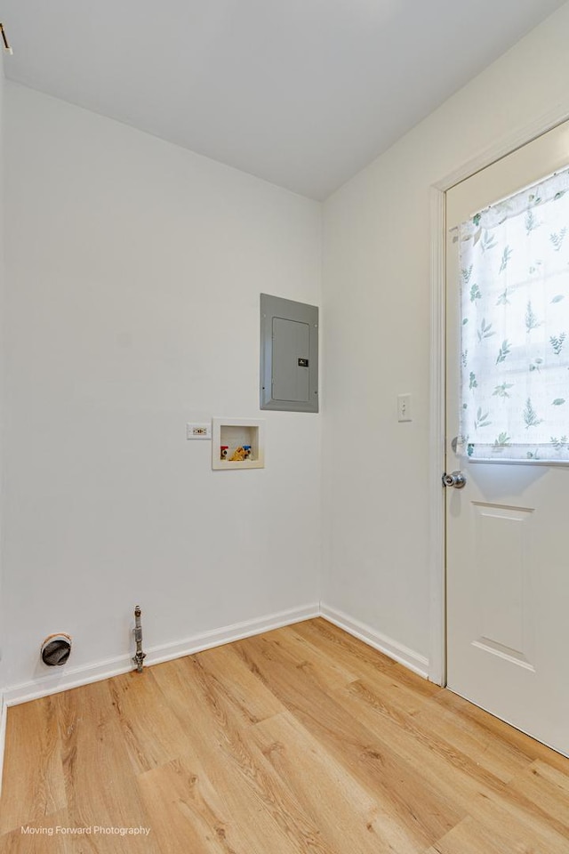 washroom featuring electric panel, light wood-type flooring, hookup for a washing machine, and laundry area