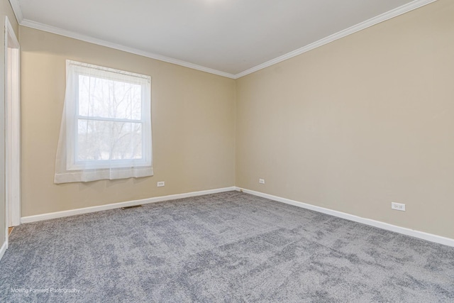 carpeted empty room featuring baseboards and crown molding