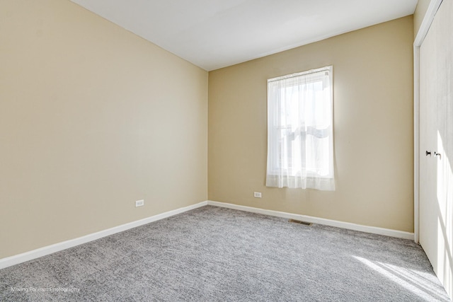 unfurnished bedroom with carpet flooring, visible vents, baseboards, and a closet