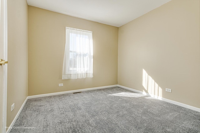 unfurnished room featuring visible vents, carpet flooring, and baseboards