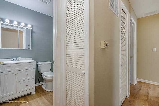 bathroom featuring a closet, visible vents, toilet, and wood finished floors