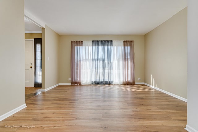 spare room with light wood-type flooring and baseboards