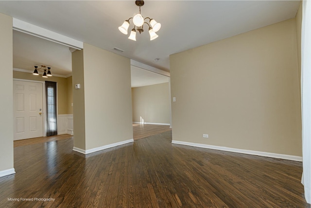 unfurnished room featuring baseboards, visible vents, ornamental molding, dark wood-type flooring, and a notable chandelier