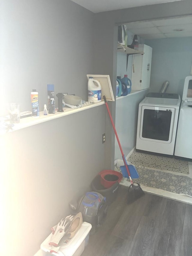 laundry area featuring washer and clothes dryer, laundry area, and wood finished floors