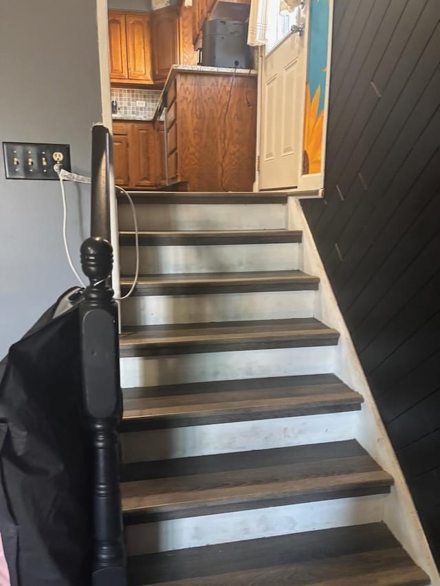 stairs featuring wood walls