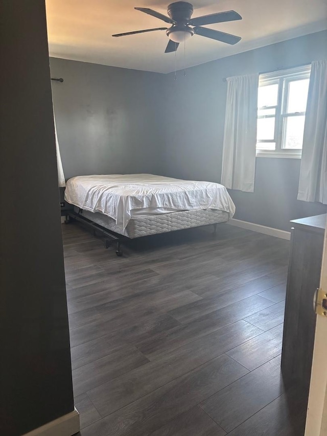 bedroom featuring dark wood finished floors, baseboards, and ceiling fan