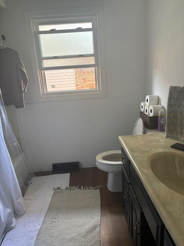 bathroom featuring toilet, wood finished floors, and vanity