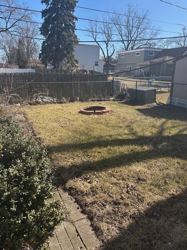 view of yard with fence and an outdoor fire pit