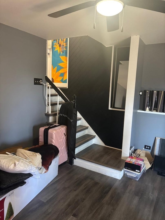 stairway with ceiling fan and wood finished floors