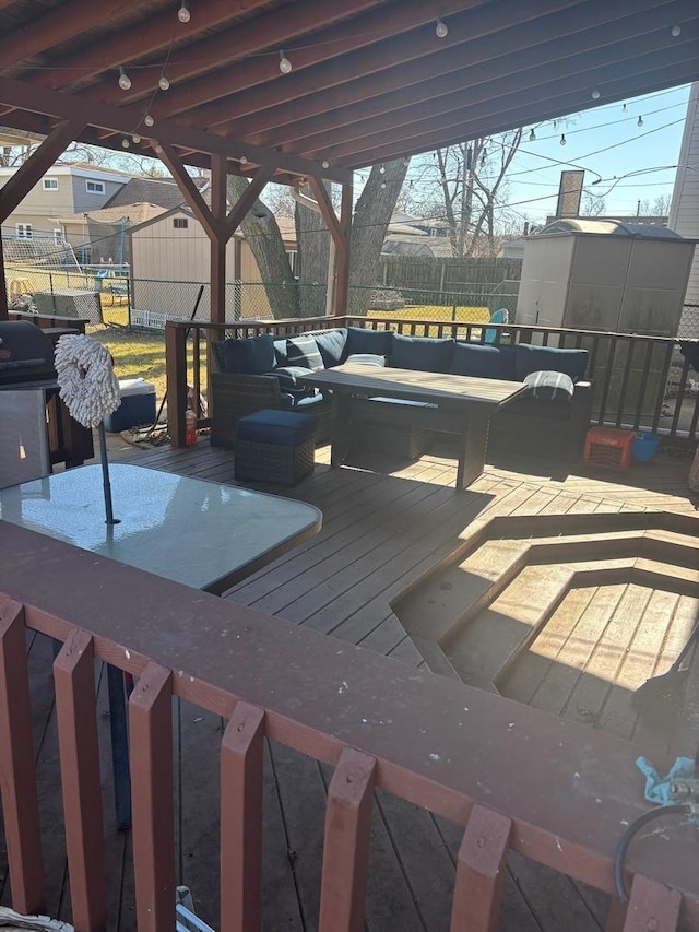 wooden deck featuring a storage shed, an outdoor structure, fence, and an outdoor hangout area