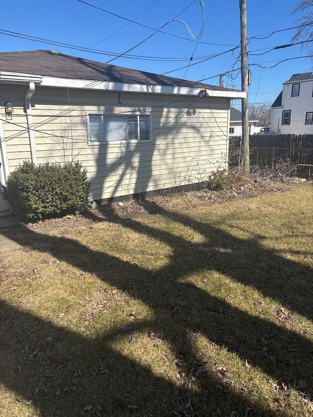 view of side of home featuring a yard and fence