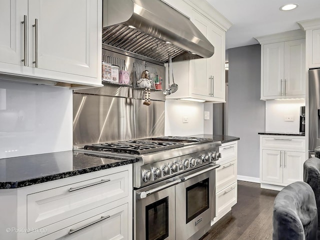 kitchen with white cabinetry, wall chimney exhaust hood, dark wood finished floors, and appliances with stainless steel finishes