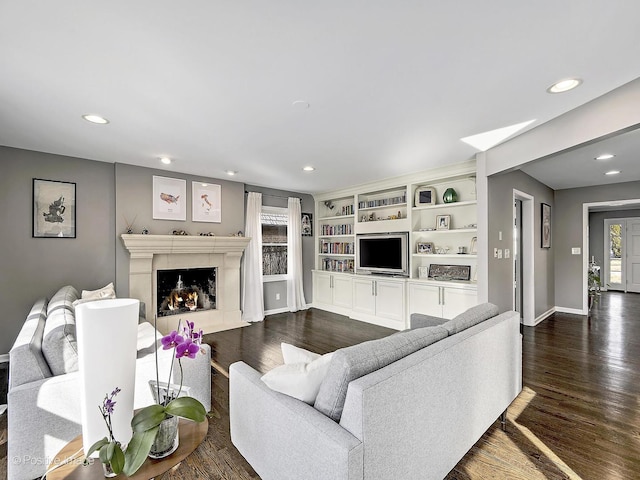 living area with recessed lighting, baseboards, dark wood-type flooring, and a fireplace