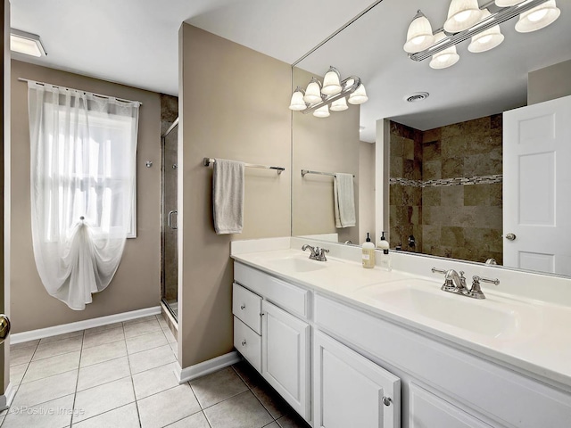 bathroom featuring tile patterned floors, a stall shower, and a sink