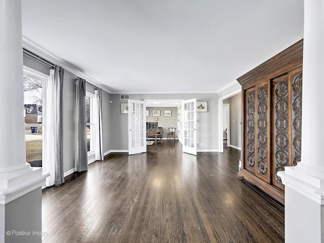 interior space with wood finished floors, baseboards, visible vents, french doors, and crown molding