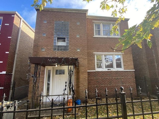 view of front of property featuring fence and brick siding