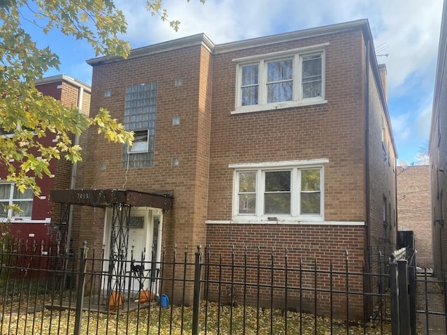 view of front of property with a fenced front yard and brick siding