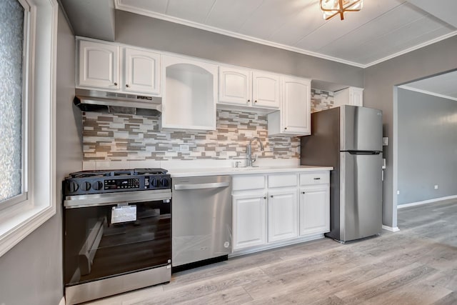 kitchen with tasteful backsplash, under cabinet range hood, light countertops, stainless steel appliances, and white cabinetry