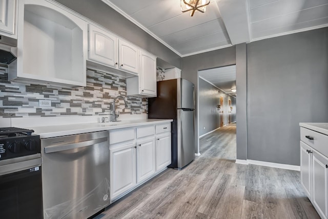 kitchen featuring light countertops, light wood-style flooring, stainless steel appliances, white cabinetry, and a sink