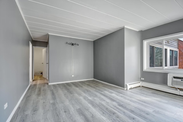 unfurnished room with a baseboard heating unit, baseboards, an AC wall unit, and wood finished floors