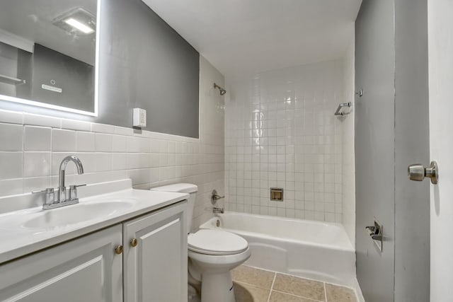 full bath featuring toilet, tile walls,  shower combination, tile patterned flooring, and vanity