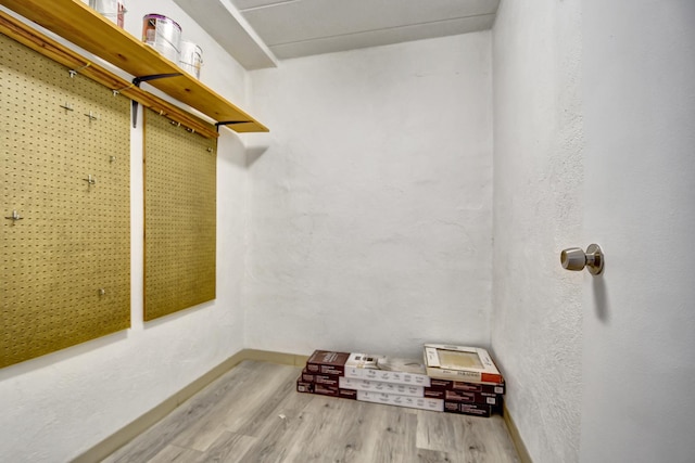 walk in closet with wood finished floors