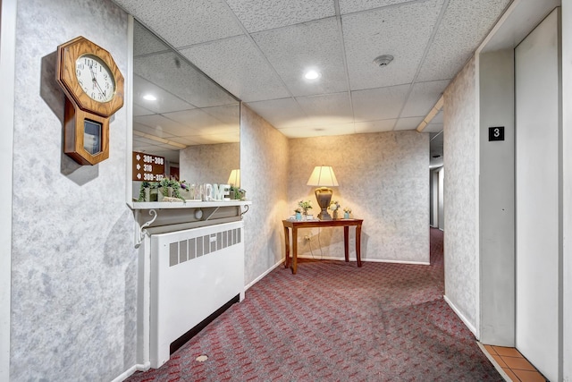 hall with elevator, radiator, a paneled ceiling, and carpet floors