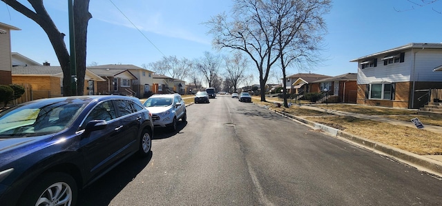 view of street with sidewalks, a residential view, and curbs