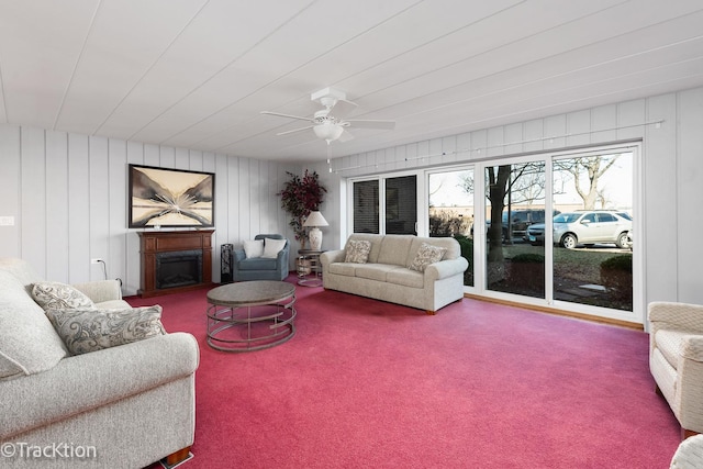 carpeted living area featuring a fireplace and a ceiling fan