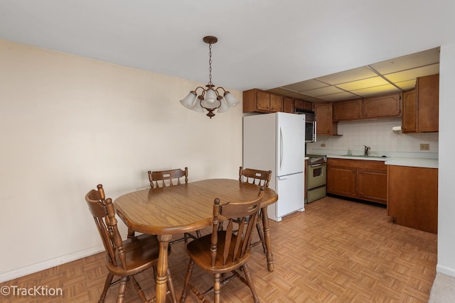 dining area with baseboards and an inviting chandelier