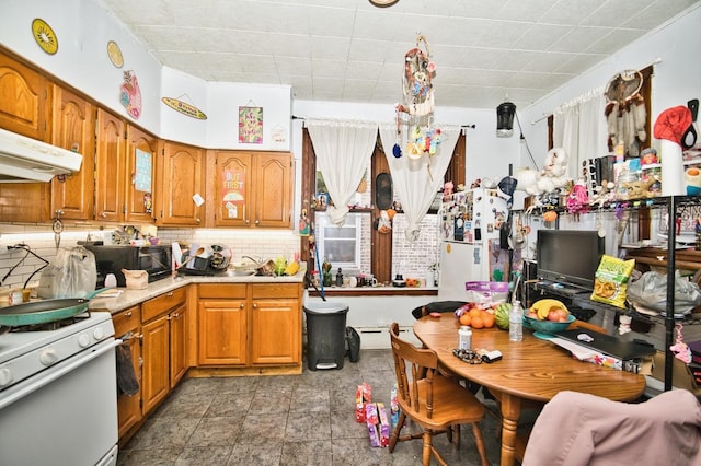 kitchen featuring backsplash, white gas stove, brown cabinetry, and black microwave