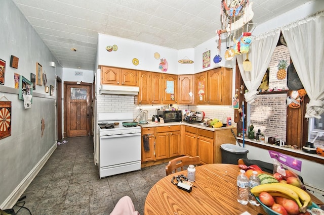 kitchen featuring under cabinet range hood, white gas range oven, black microwave, light countertops, and decorative backsplash