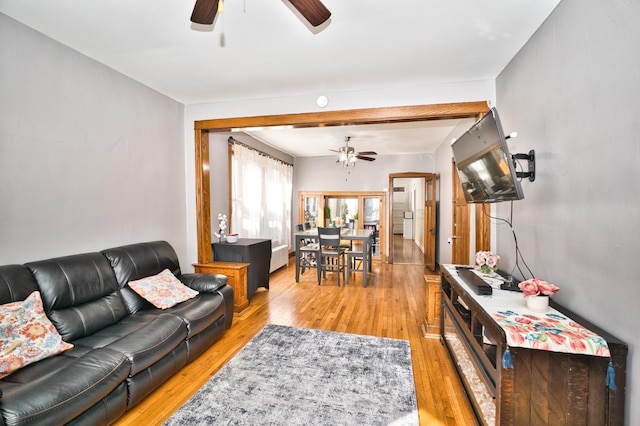 living room with light wood-style floors and a ceiling fan