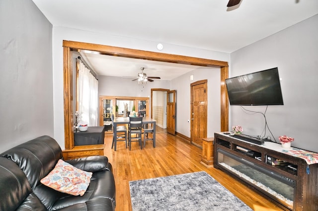 living area with light wood finished floors and a ceiling fan