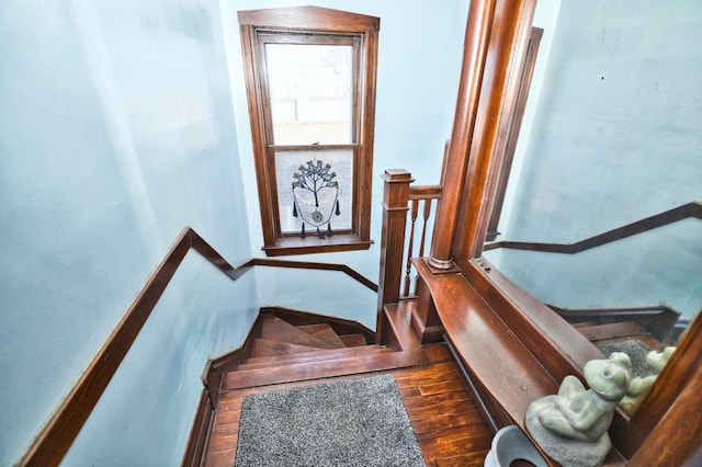 staircase with baseboards and wood finished floors