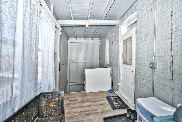 bathroom featuring brick wall and wood finished floors