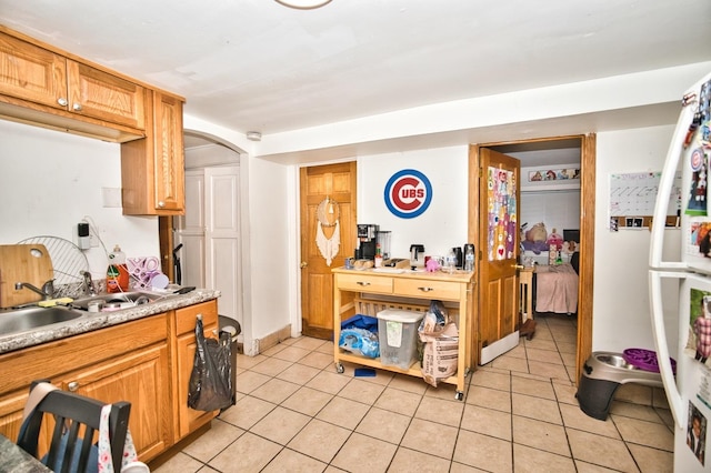 kitchen with a sink, light tile patterned flooring, and light countertops