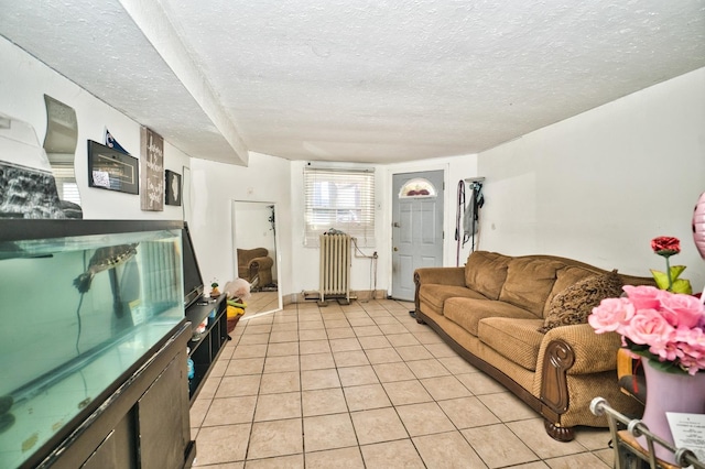 living area featuring radiator, light tile patterned floors, and a textured ceiling