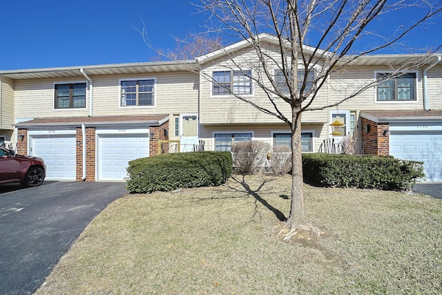 view of front of house featuring an attached garage, brick siding, and driveway