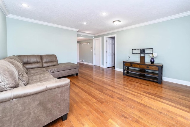 living room featuring light wood-type flooring, baseboards, and ornamental molding