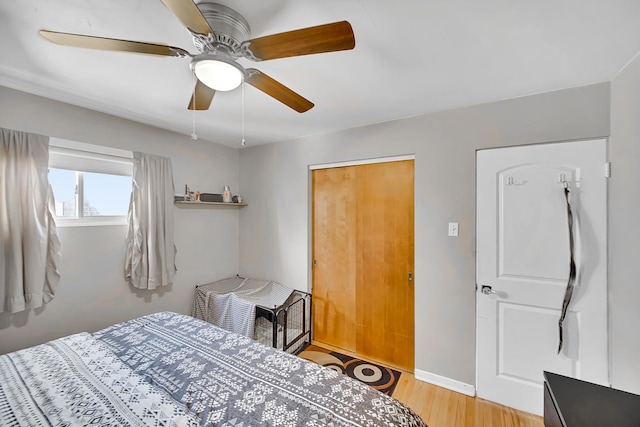 bedroom featuring a ceiling fan, light wood-type flooring, and baseboards